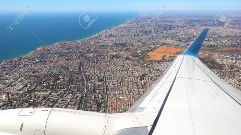 avion de pasajeros sobrevolando una ciudad