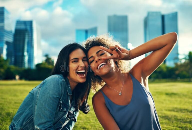 dos personas sonriendo juntas en un parque