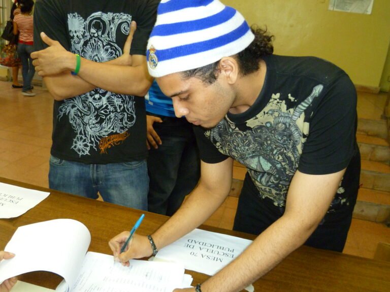 estudiantes firmando documentos en una escuela