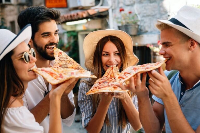 grupo de amigos disfrutando una pizza al aire libre