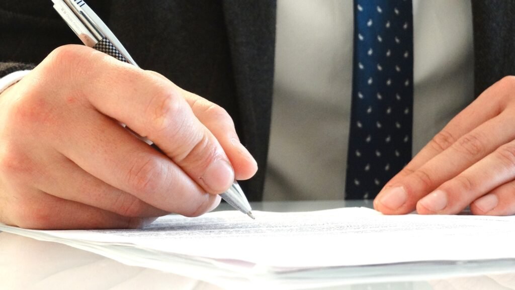manos firmando un documento legal