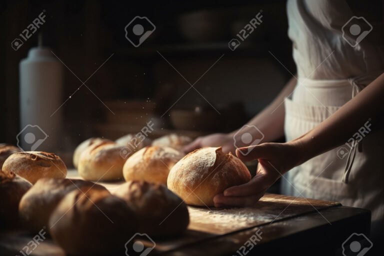 De dónde proviene la expresión "el pan nuestro de cada día" 4 manos tomando pan fresco en la mesa