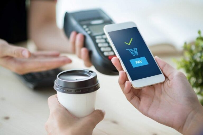 manos usando un telefono movil para pagar